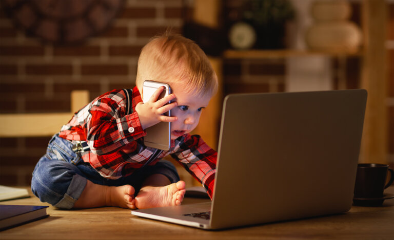 concept of baby boy working on computer and talking on phone